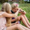 kaleidoscoop-speelgoed-buiten-kinderen Kind kijkt door kleurrijke Huckleberry kaleidoscoop